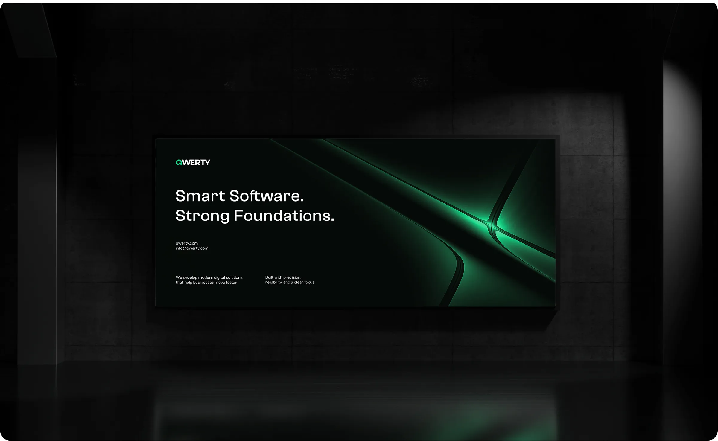 A backlit QWERTY billboard in a dark interior, reading “Smart Software. Strong Foundations.”
