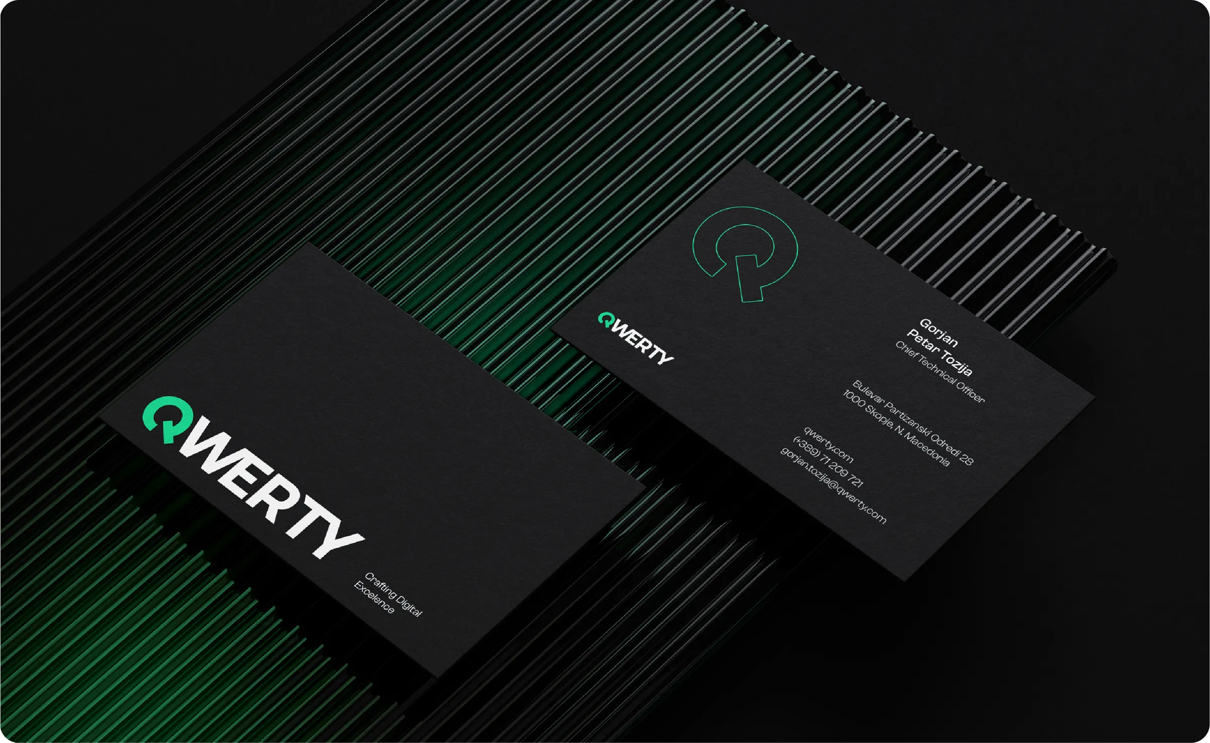 QWERTY business cards face up on black card stock, wordmark side and contact side